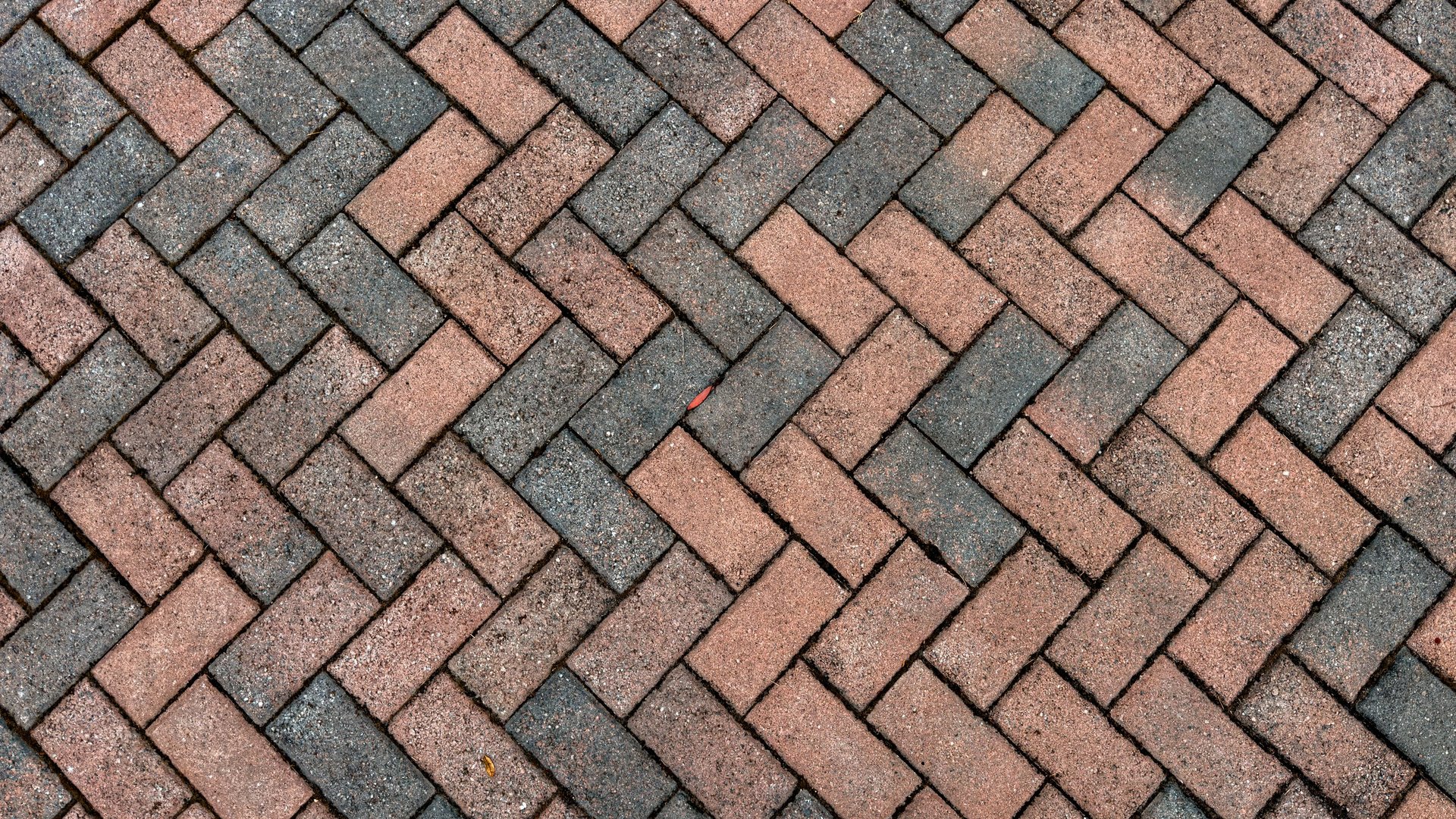 Beautifully restored red and charcoal brick pavers in a herringbone pattern
